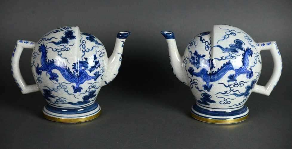 	• Pair of white teapots with blue dragon and cloud decorations, round bases, slightly egg shaped bodies whose tops have stepped areas.