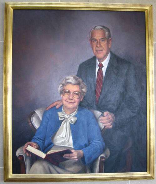 Color portrait of Doctor Parks standing behind chair of sitting Mrs. Parks.