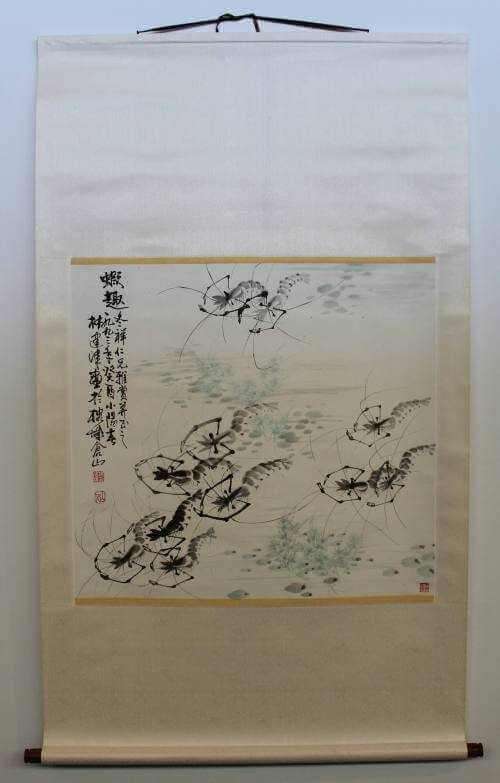Hanging scroll showing cluster of lightly sketched shrimps amidst pale sea vegetation and rocks in gray and light blue with three columned calligraphy inscription on the far left.