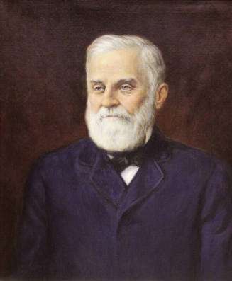 Shows Welch with white hair and beard, blue suit