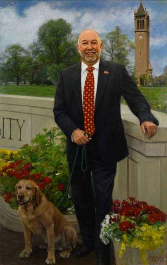 Steven Leath with his dog, Campanile in the background near the Iowa State University Wall