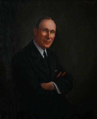 Portrait of Raymond Hughes, arms folded, looking at us and smiling