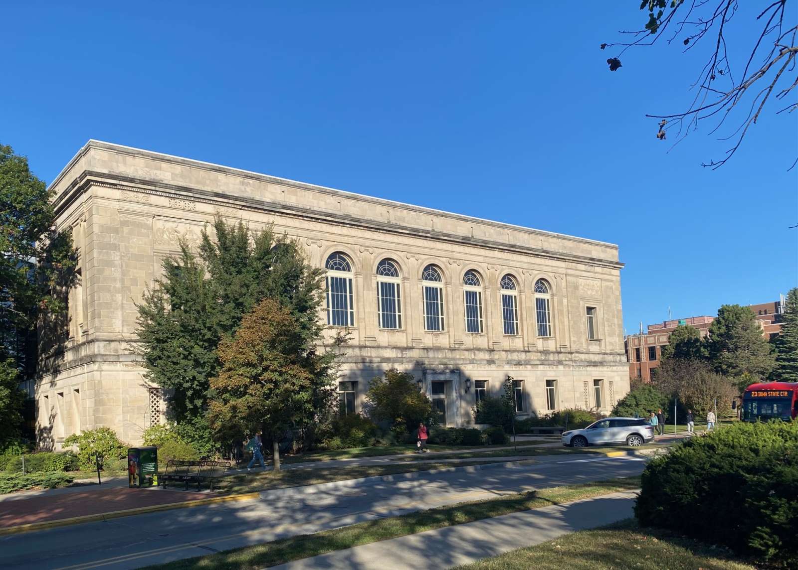 Original library building, two-story, limestone structure against a bright blue sky