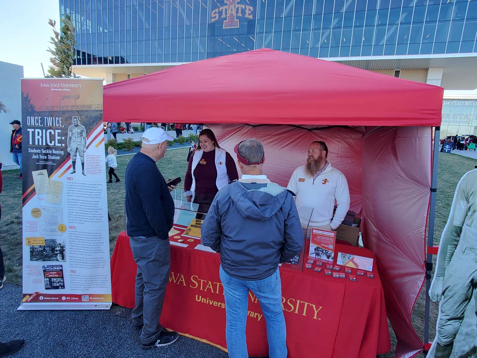 Rebecca Wells, student life archivist, and Greg Bailey, Special Collections and University Archives department head, speak to visitors at the SCUA outreach tent before the Jack Trice Legacy Game on Oct. 7, 2023. 